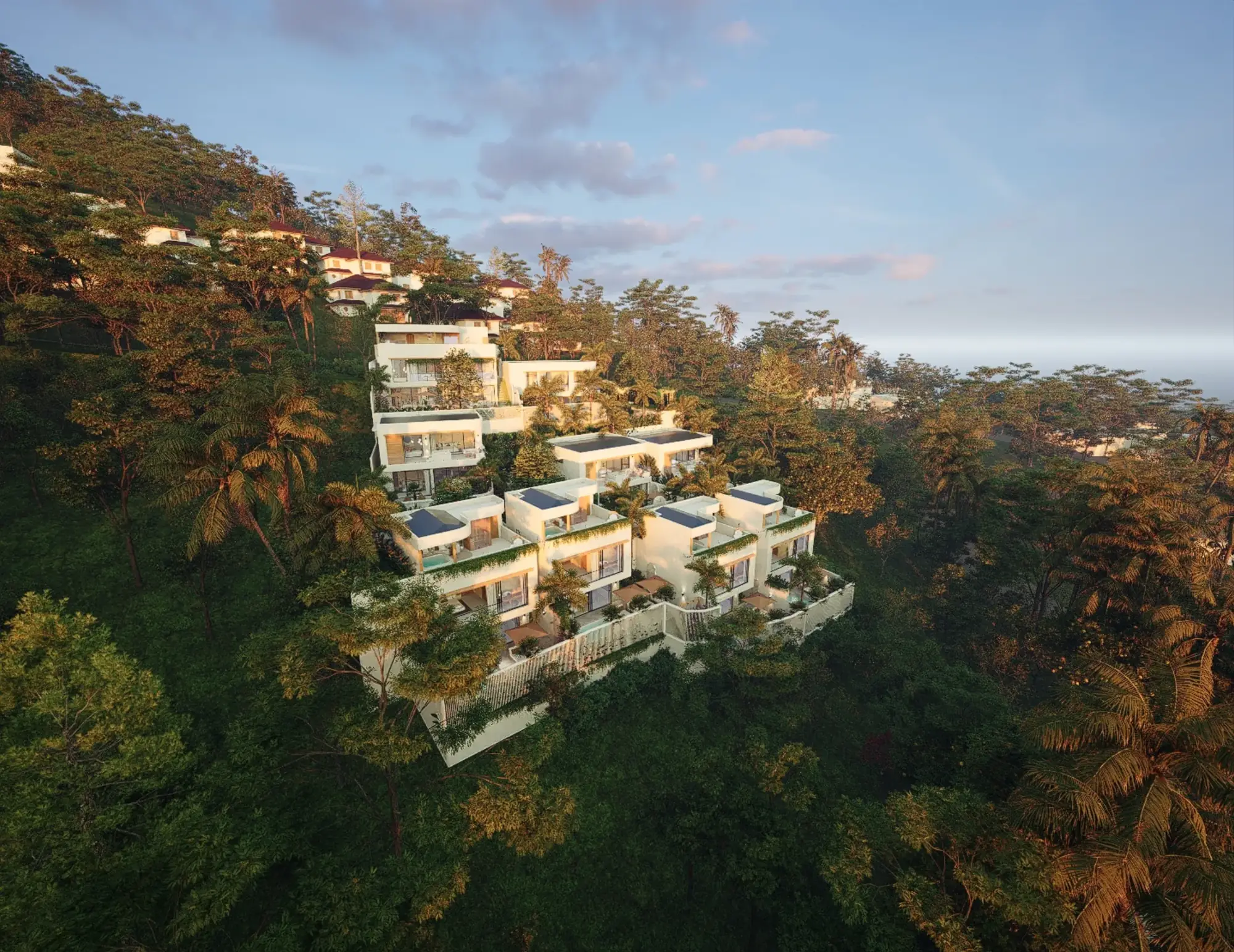 Golden-hour aerial view of the LIMEANA hillside opening onto the Amed coastline and ocean
